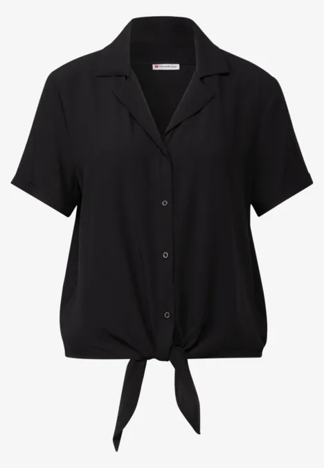 Schwarze Bluse mit kurzen Ärmeln und Knoten vorn.